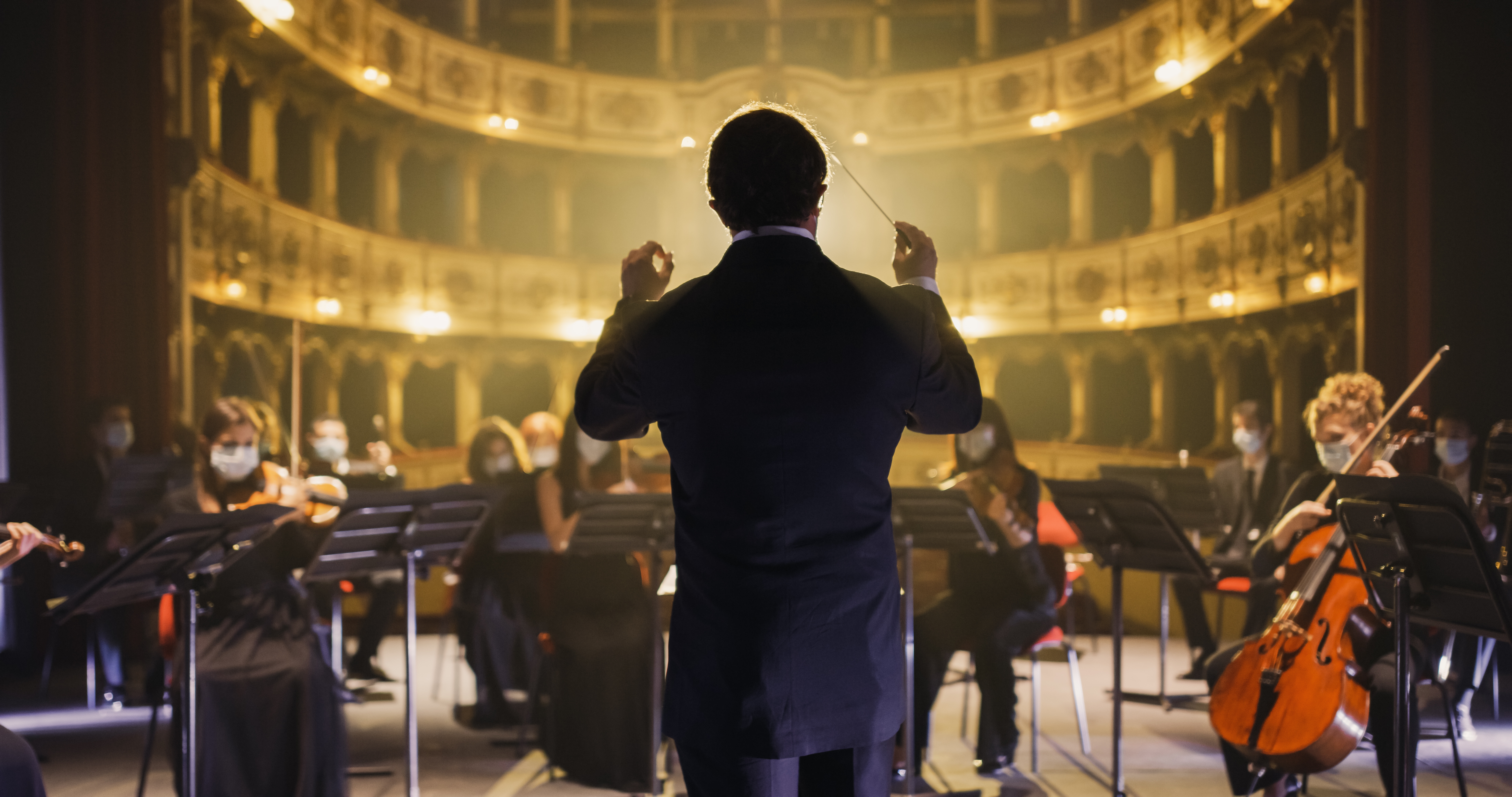 Close-up of a conductor leading an orchestra, representing conductor jobs and opportunities on mondomusic, the networking app for classical musicians.